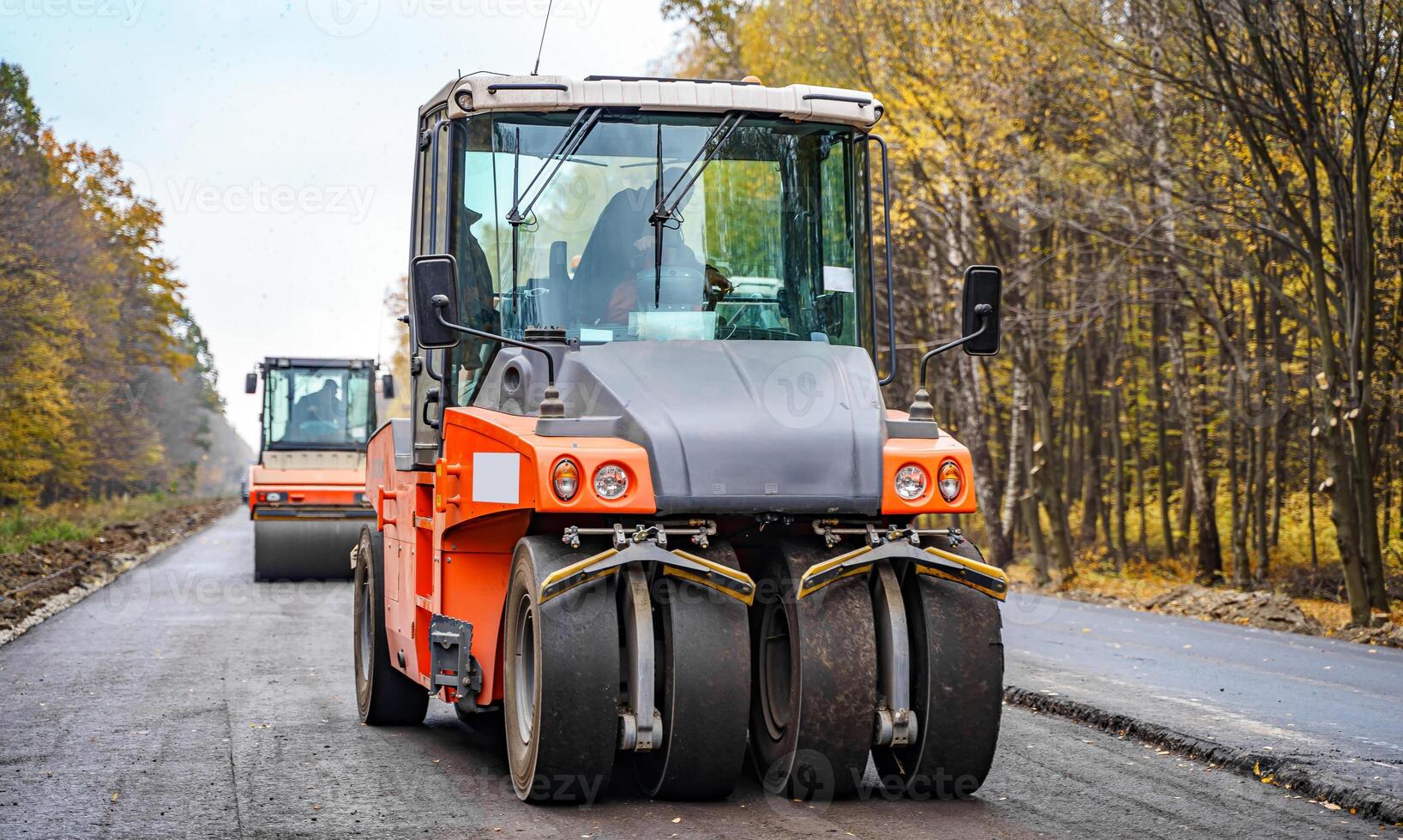 Road repair, compactor lays asphalt. Heavy special machines. Asphalt paver in operation. Side view. Closeup. photo