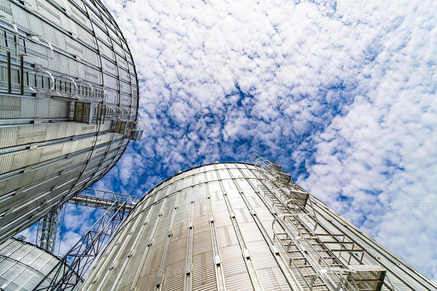 Special grain elevators for crop storage. Metal bridge from the roof of metal tank. View from below. Closeup. photo
