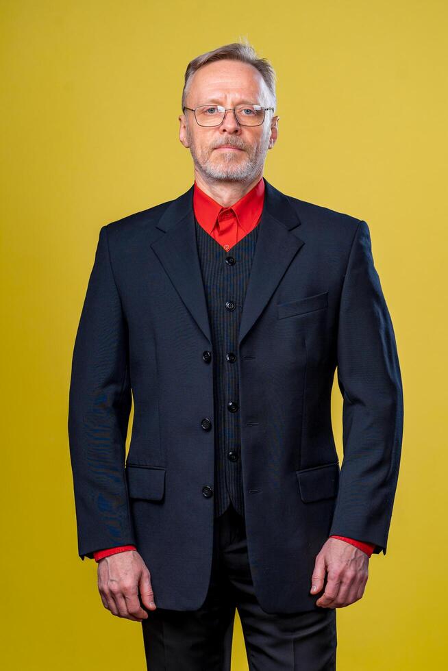 Content senior business man smiling in a dark suit. Hands straight. Red shirt. Confident. Business style concept photo