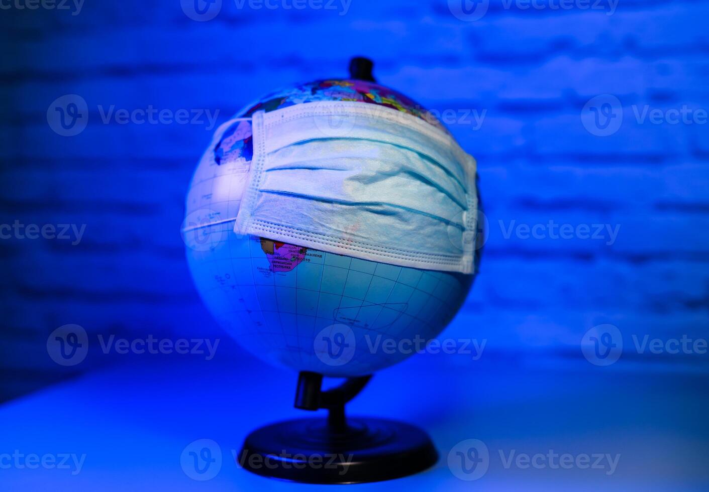 Medical mask on globe against a virus. Save the planet. Stop pandemic. photo