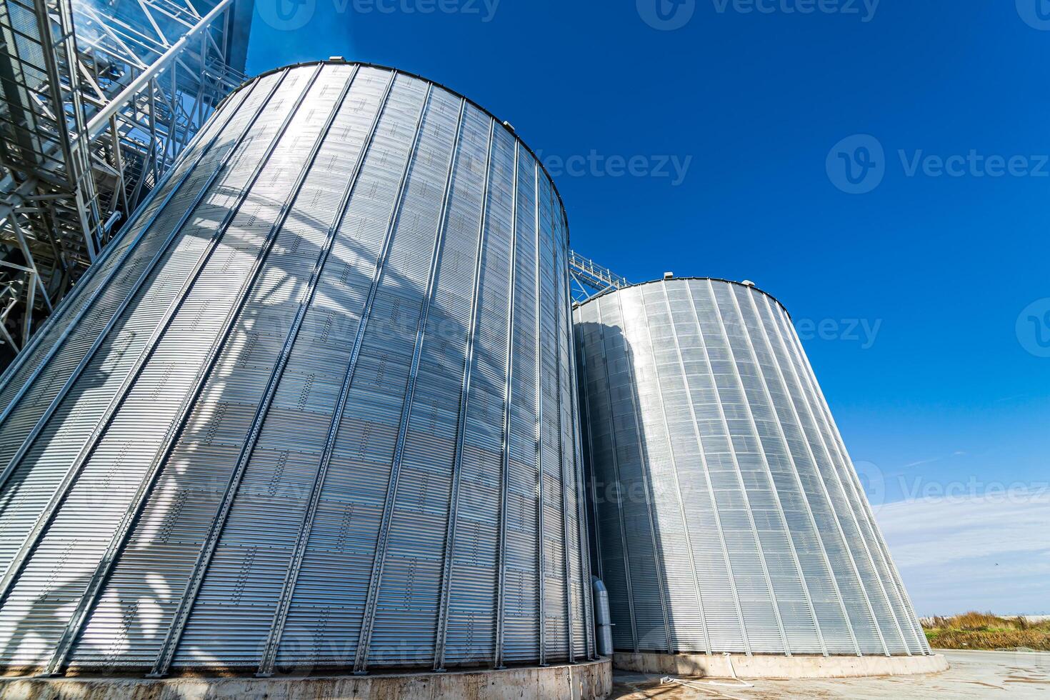 Low angle view of the great cylindric warehouse with blue sky. Big metallic industrial construction. Steel store photo