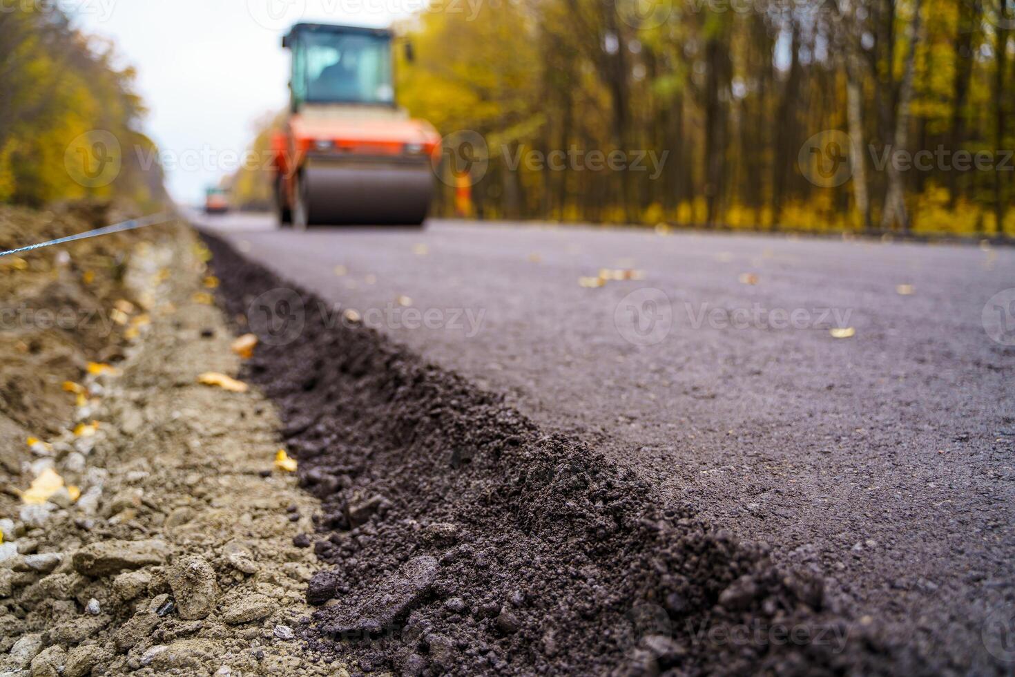 Road repair, compactor lays asphalt. Heavy special machines. Asphalt paver in operation. Side view. Closeup. photo