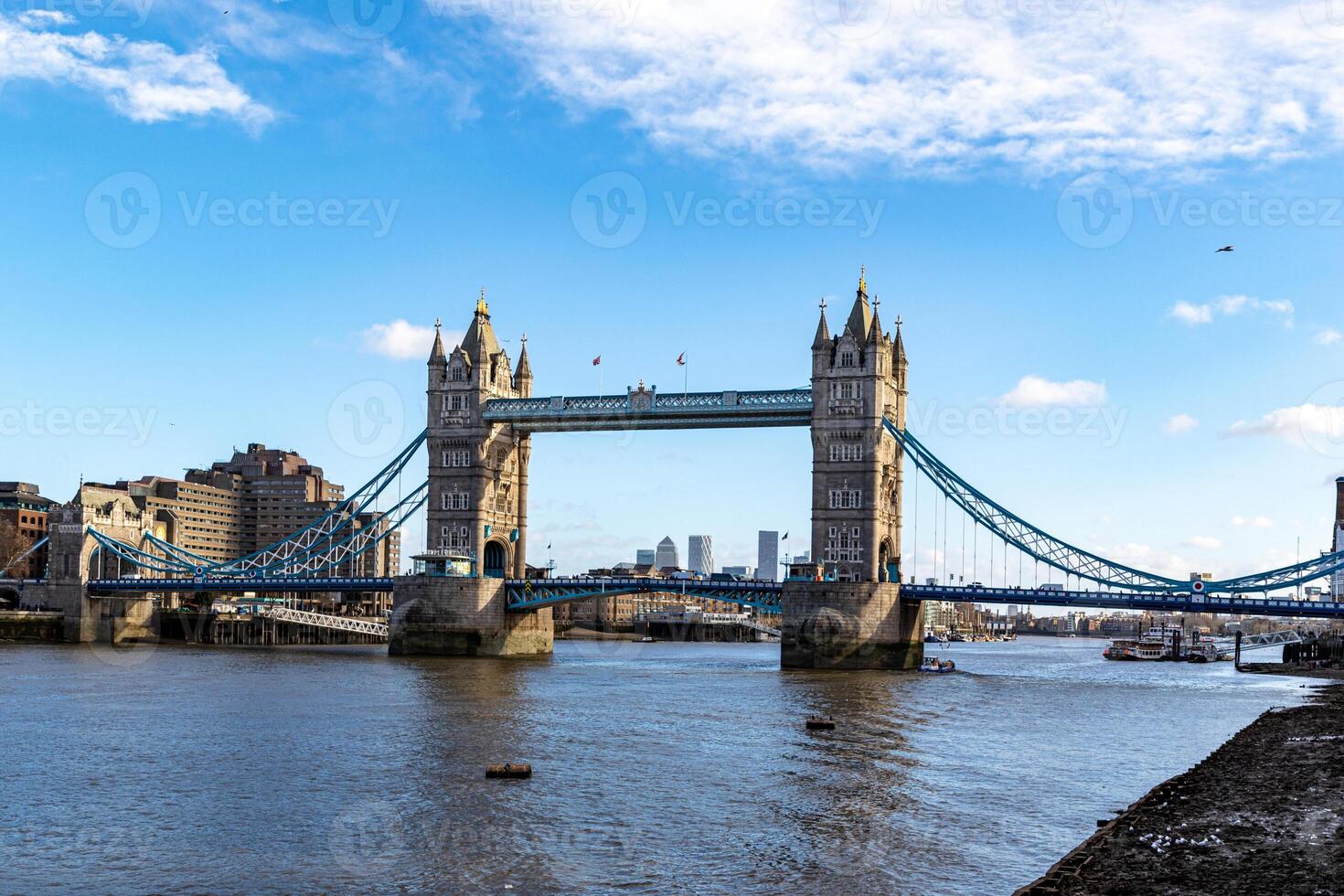 Sunny day view of the iconic Tower Bridge over the Thames in London, with clear blue skies and fluffy clouds. photo