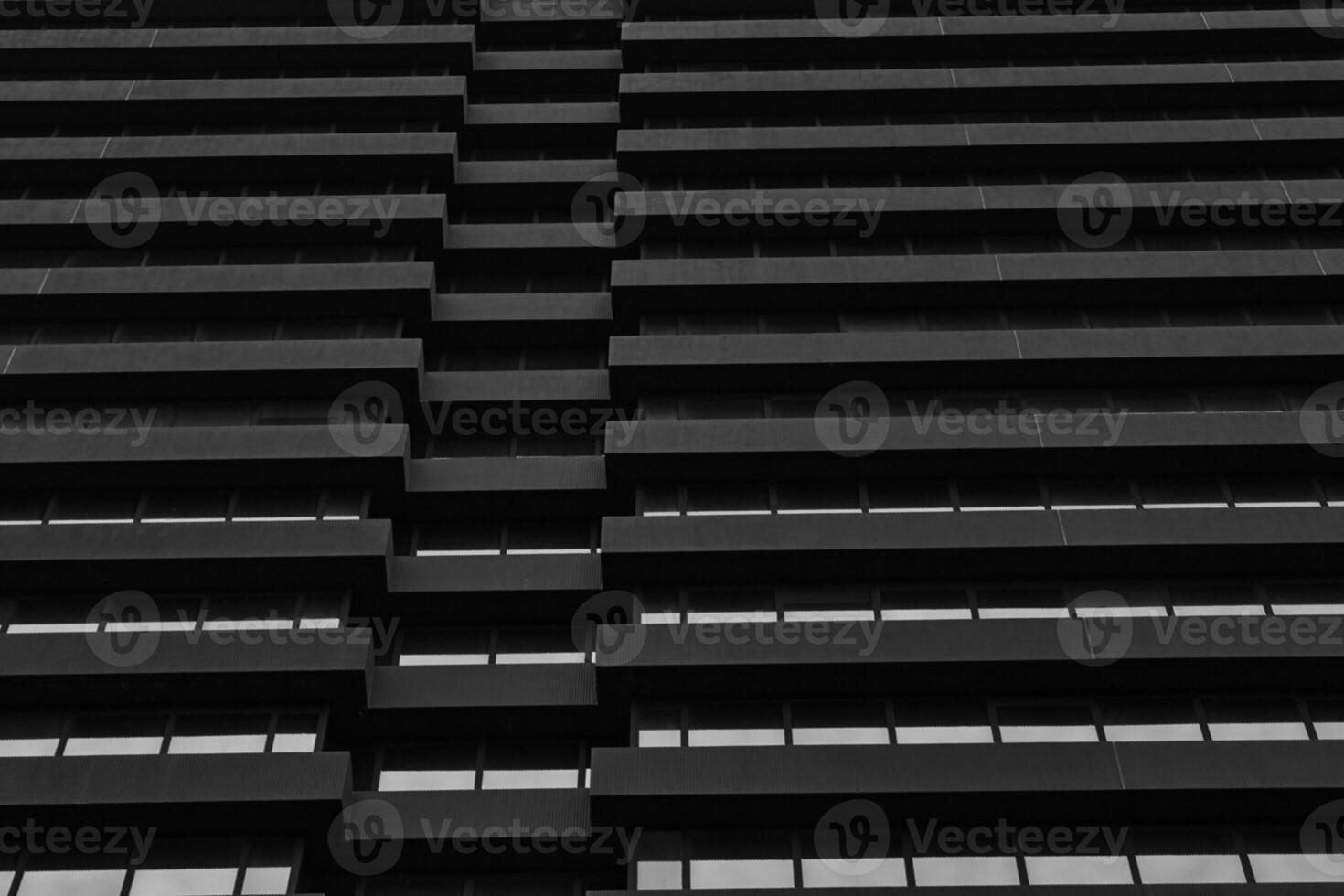 Monochrome image of modern building facade with geometric pattern of windows and ledges, abstract urban background in Leeds, UK. photo