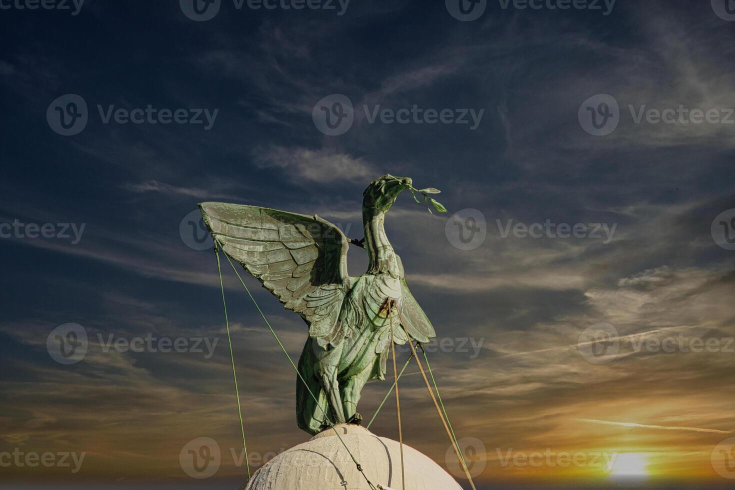 Bronze statue of an angel with outstretched wings against a vibrant sunset sky in Liverpool, UK. photo