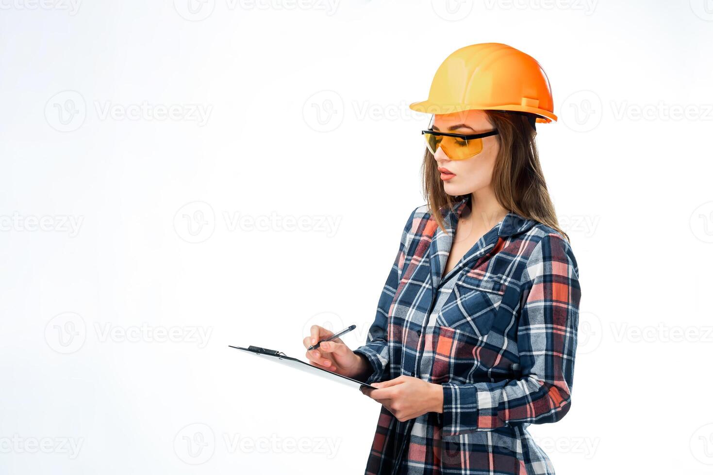 Serious attractive architect woman with hard hat. Isolated on white background. Smart, clever, lovely stylish nice cute brunette girl in casual clothes. Wearing protective glasses, holding folder. photo