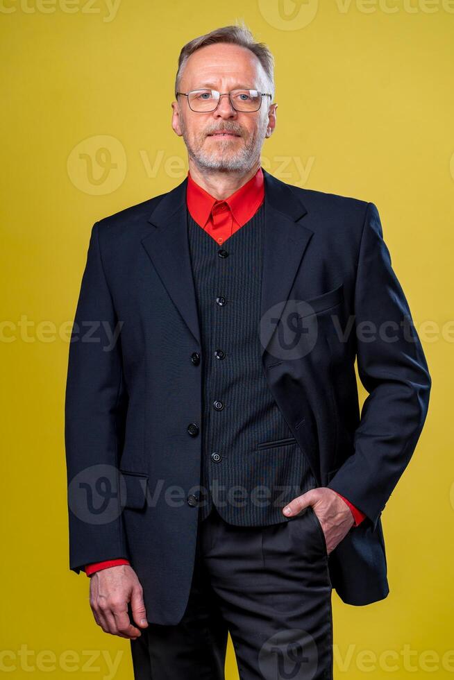 Content senior business man smiling in a dark suit. Hands straight. Red shirt. Confident. Business style concept photo