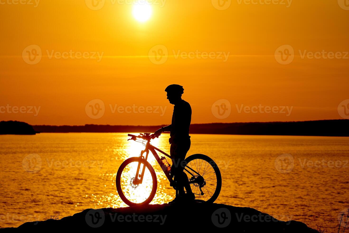 Silhouette of the cyclist riding on a sports bike at sunset. Active lifestyle concept. photo