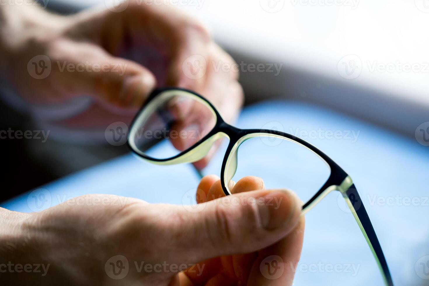 Man s hands with correcting glasses. Modern eyewear. Correcting eyesight. photo
