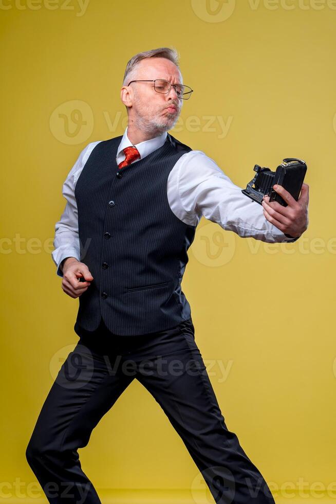 Middle aged man makes a selfie in a studio. Isolated background. Close up. photo