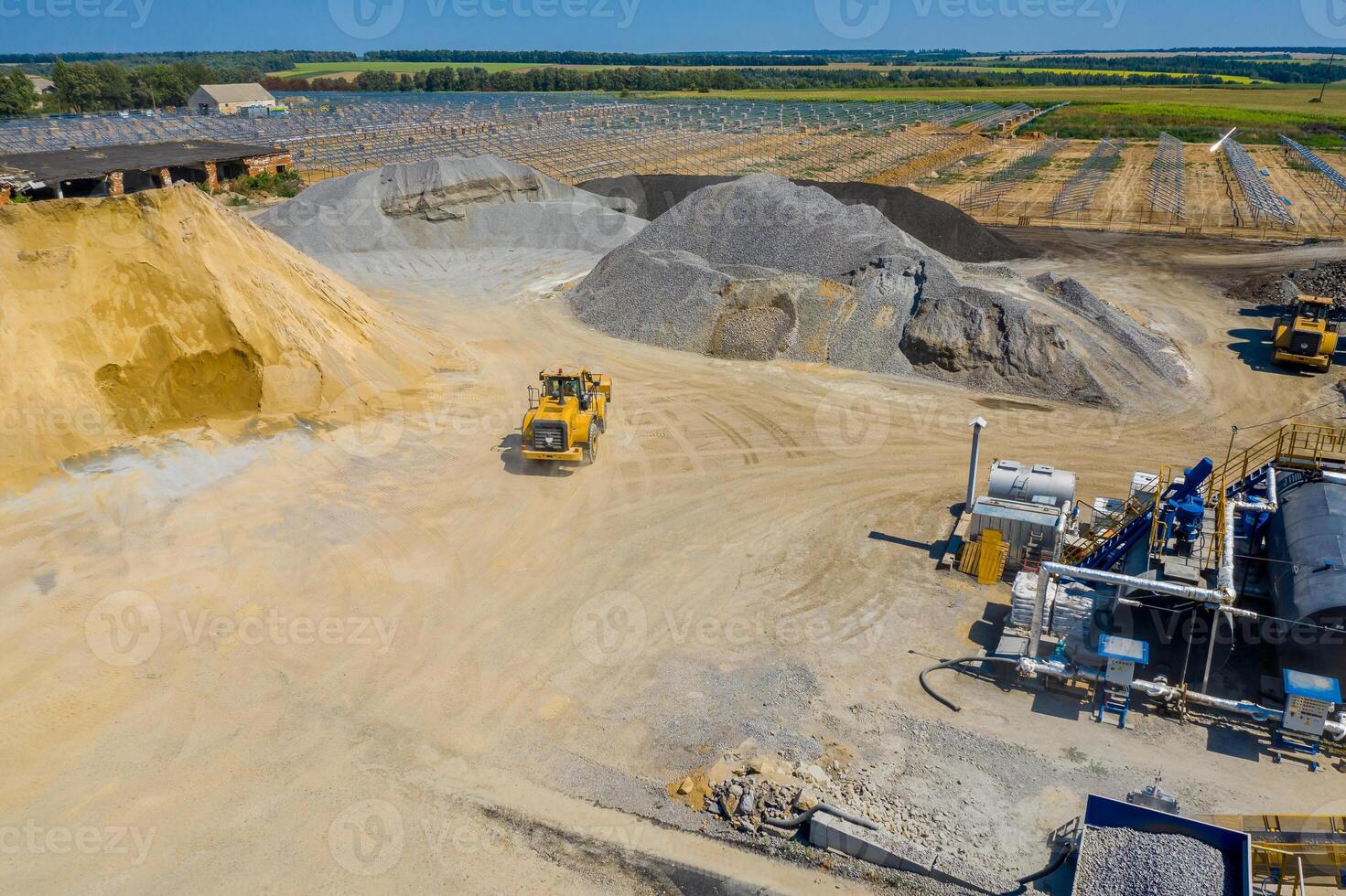 An industrial asphalt plant surrounded by piles of gravel. Asphalt mixture. Harmful production. A mixture of bitumen and gravel, a mix machine. Aerial view photo
