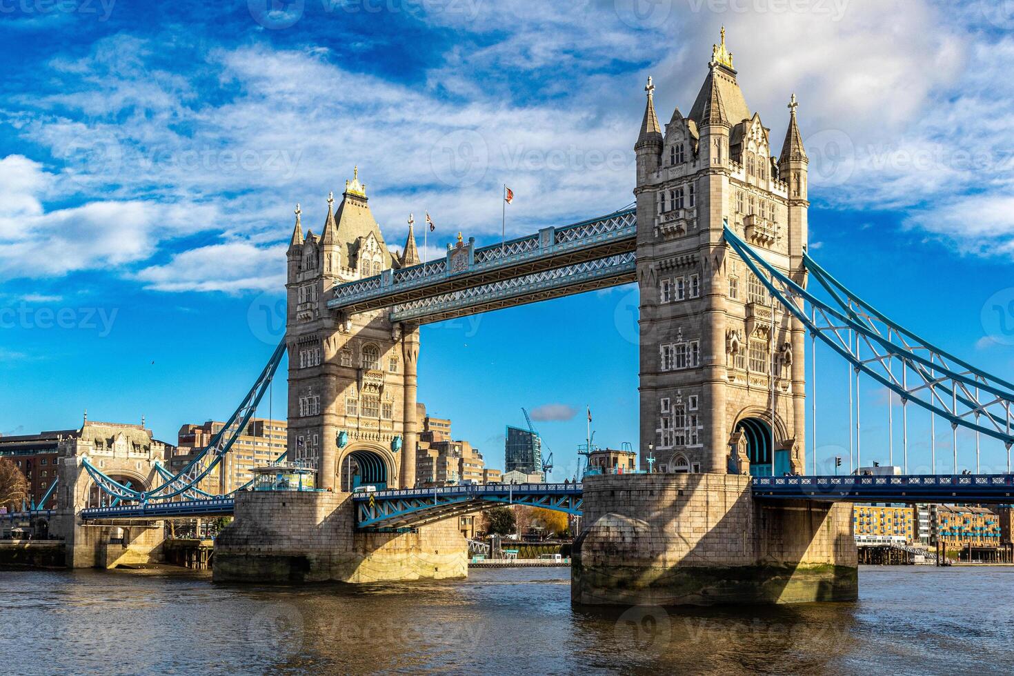 soleado día ver de el icónico torre puente terminado el río Támesis en Londres, Reino Unido, con azul cielo y mullido nubes foto