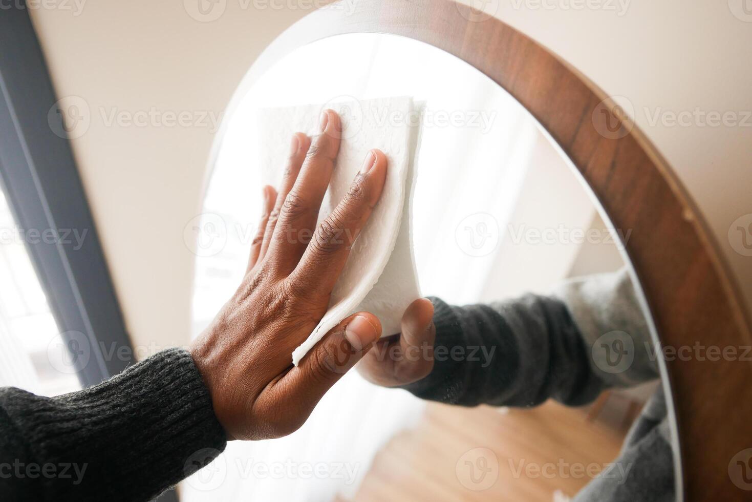 mano limpieza espejo con un pañuelo de papel foto