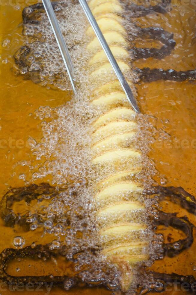 fried chips potatoes frying in boiling hot oil in a deep fryer, photo