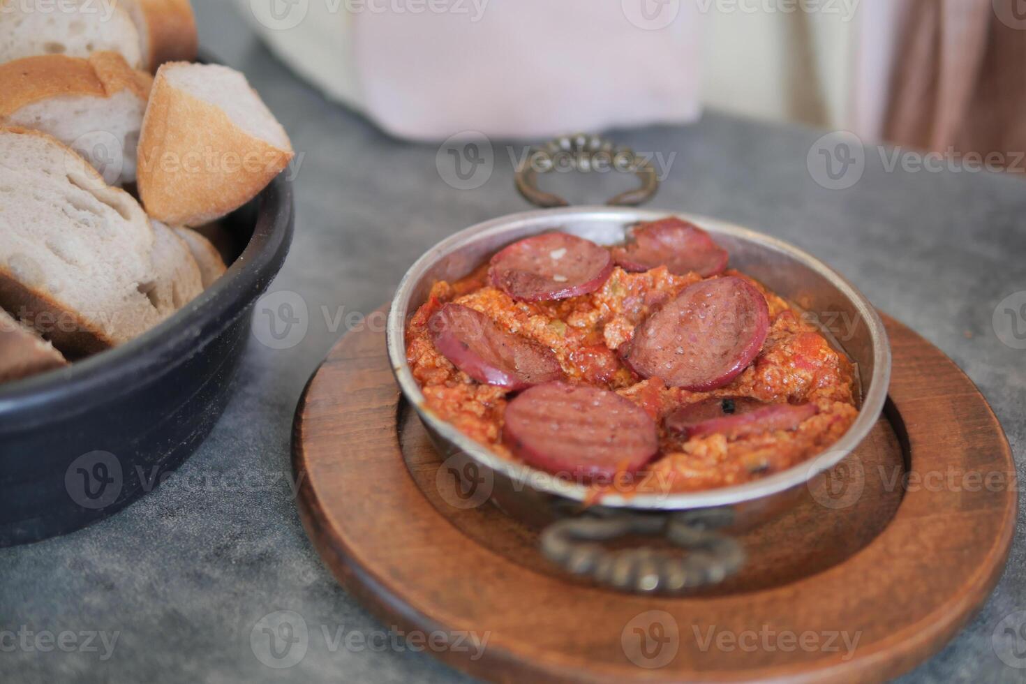 Turkish Menemen with sausage in a frying pan. . photo