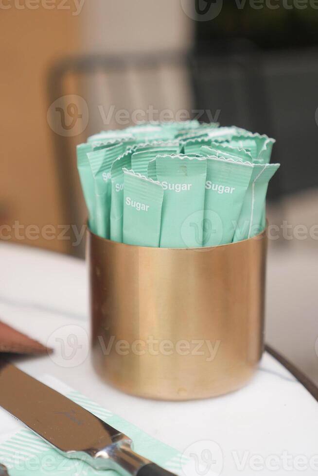 white sugar in a paper packet on table photo