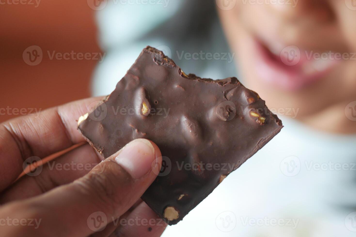 child eating dark chocolate close up photo