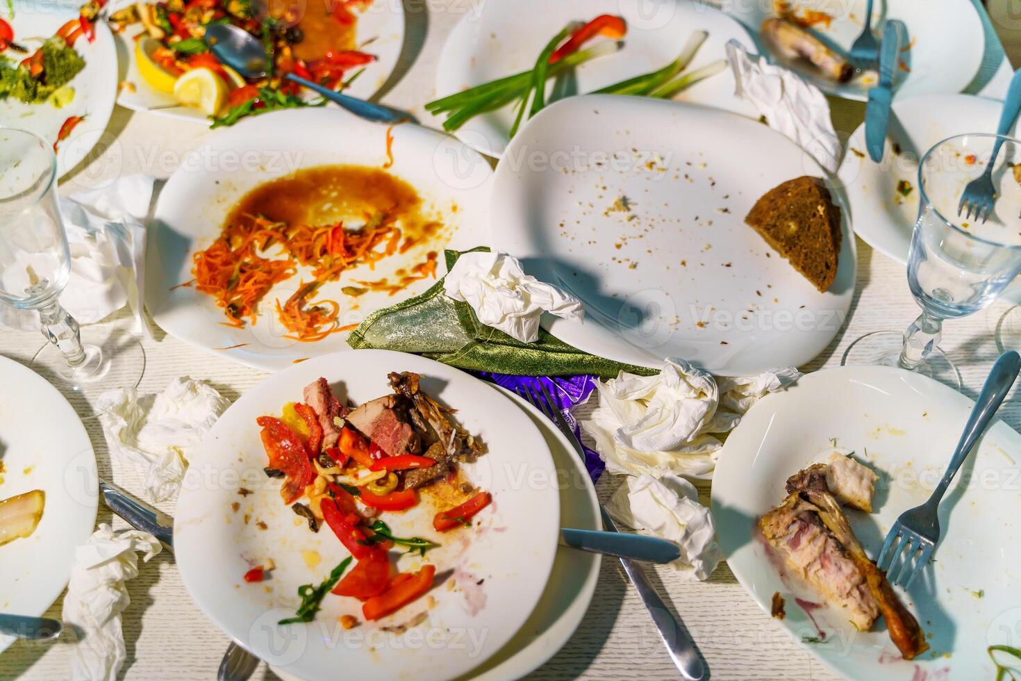 Empty dirty plates with spoon and forks on the table. Cropped photo. photo