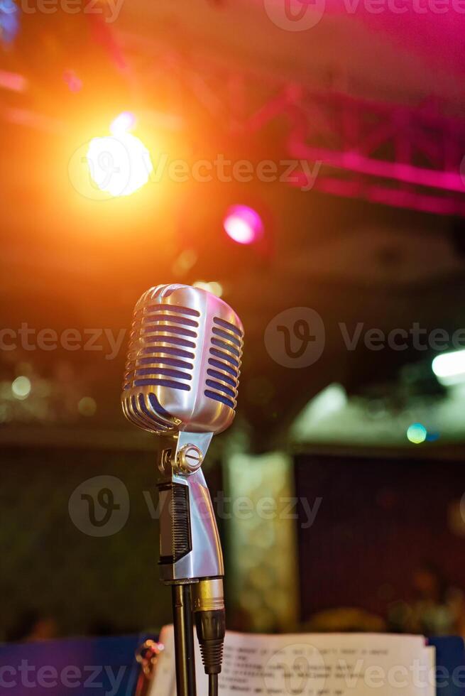 Microphone in concert hall or conference room on a dark background. Closeup photo