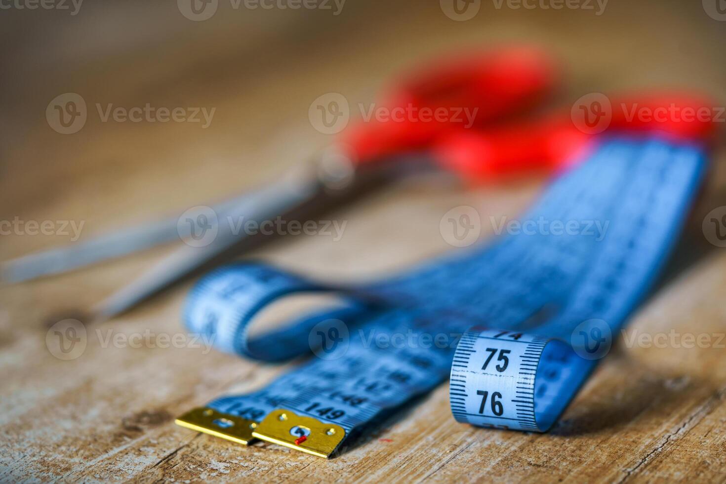 Measuring tape and scissors with red handles. Tailor s work. Tailor concept. Close-up. photo