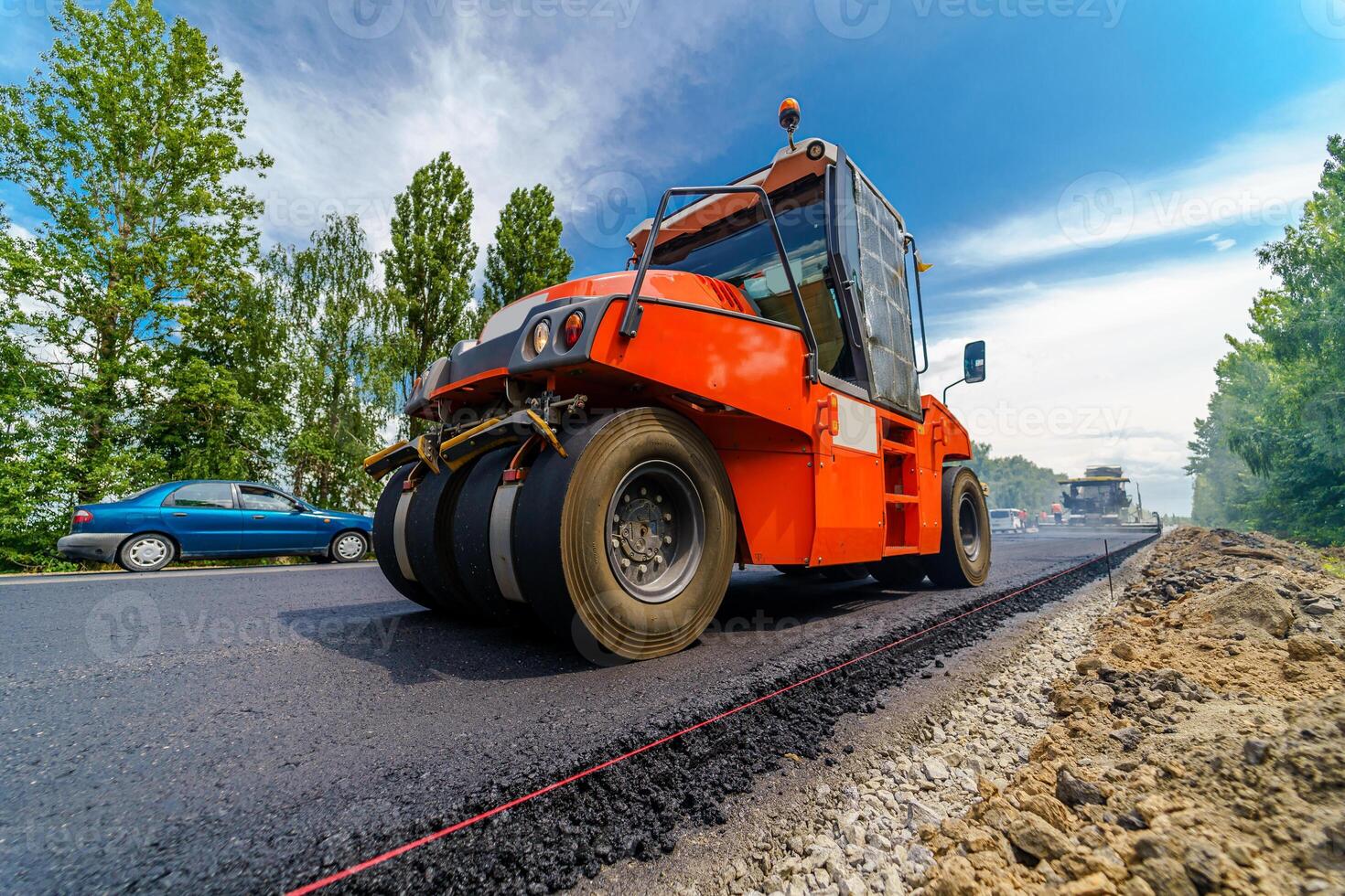 Tandem vibration roller compactor working on asphalt pavement, selective focus on road repair. photo