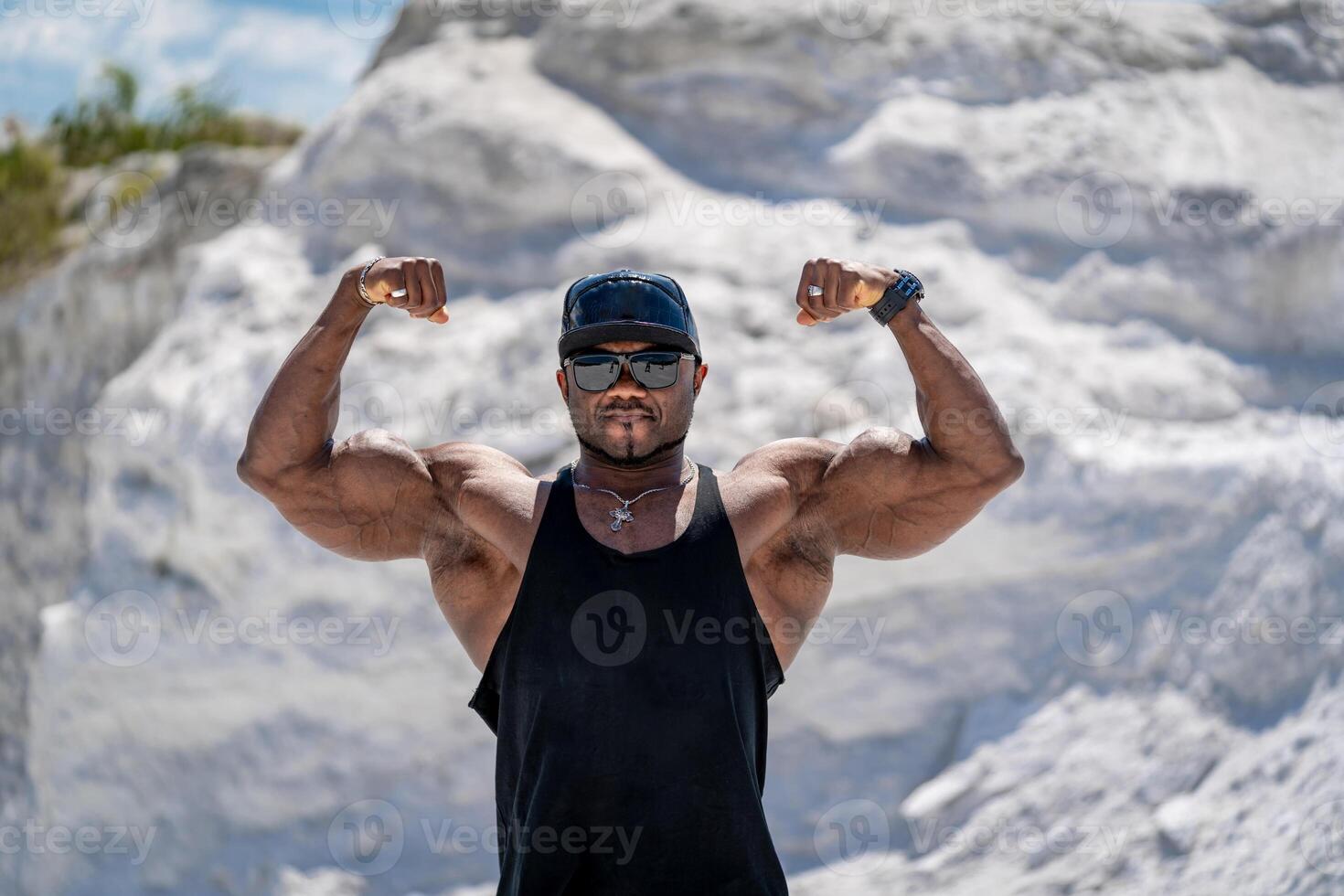 Young bodybuilder with srong muscles. Strong muscular man showing power outdoor. photo