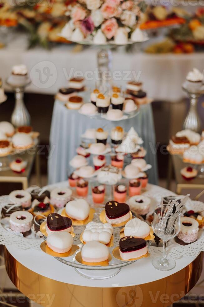 Almond cookies, sweet cakes for a wedding banquet. A delicious reception, a luxurious ceremony. Table with sweets and desserts. Delicious colorful French desserts on a plate or table. Candy bar. photo