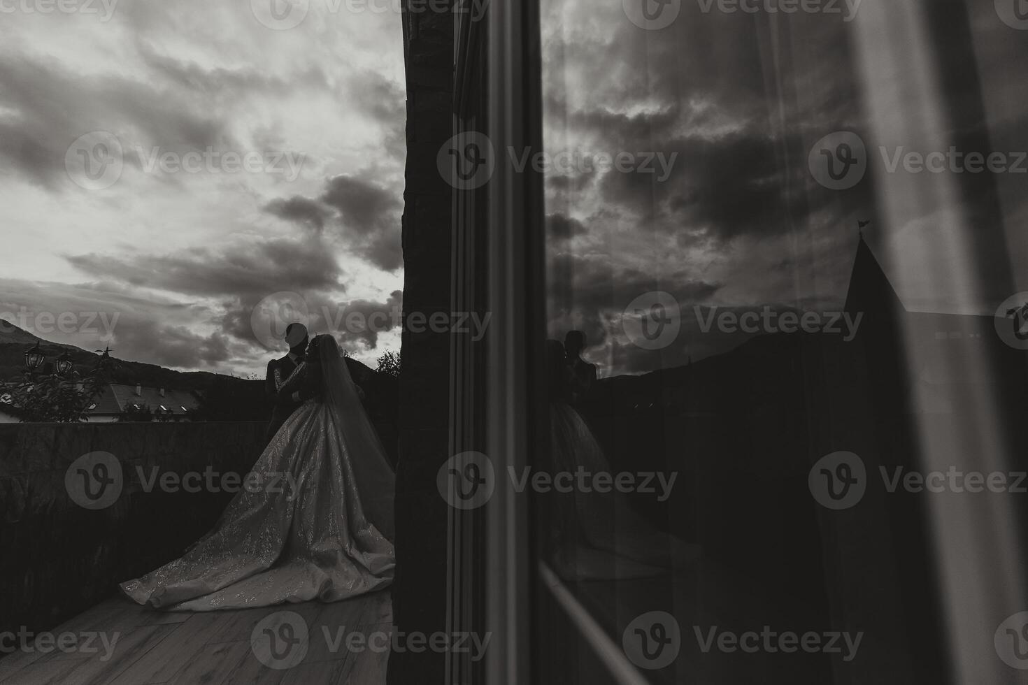 A handsome groom embraces his beloved in a beautiful location. Reflection in the mirror of the bride and groom. Wide format photo. photo