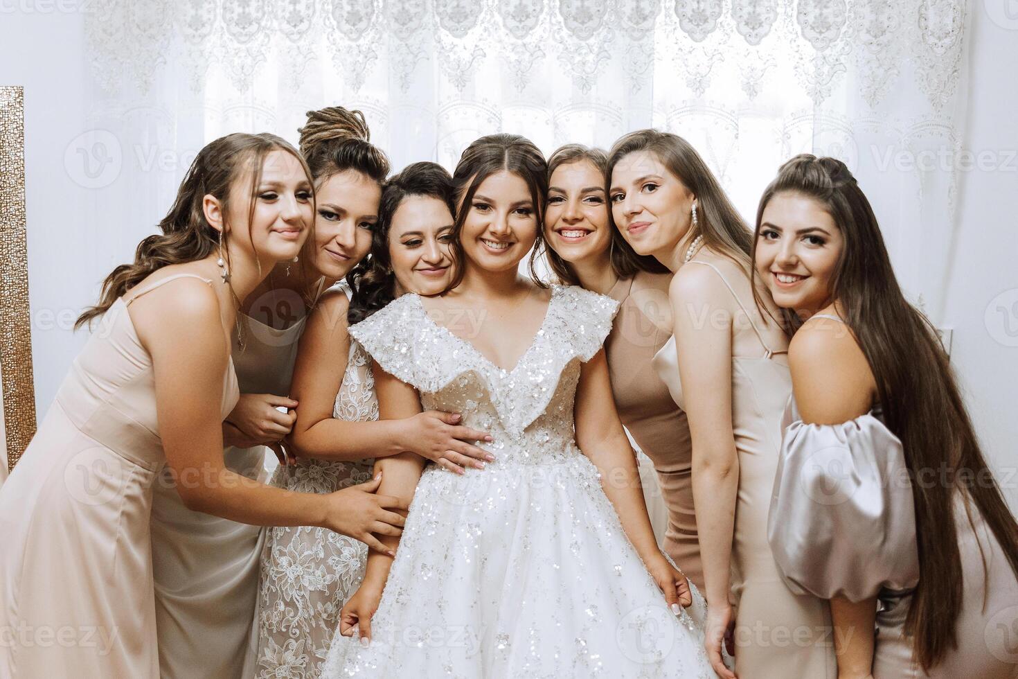 retrato de el novia con su amigos. elegante y elegante novia con su amigos en pareo vestidos en el habitación en el Mañana. muchos hermosa muchachas en uno foto. foto