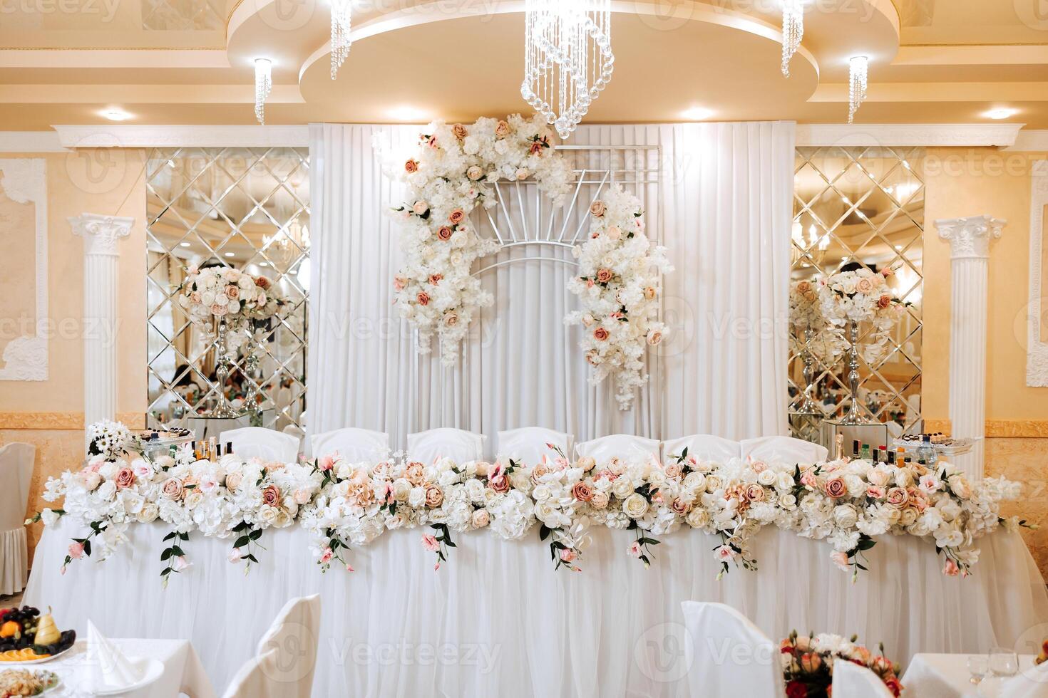 table setting in a restaurant for a holiday. Wedding decor for the newlyweds at the banquet. Floristry of fresh flowers and candles, boho style. Catering for the bride and guests. photo