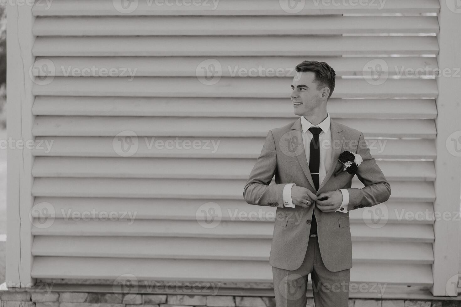 Portrait of a handsome young groom on an autumn day outdoors in an elegant suit. Outdoor photo. Handsome man in a business suit. photo