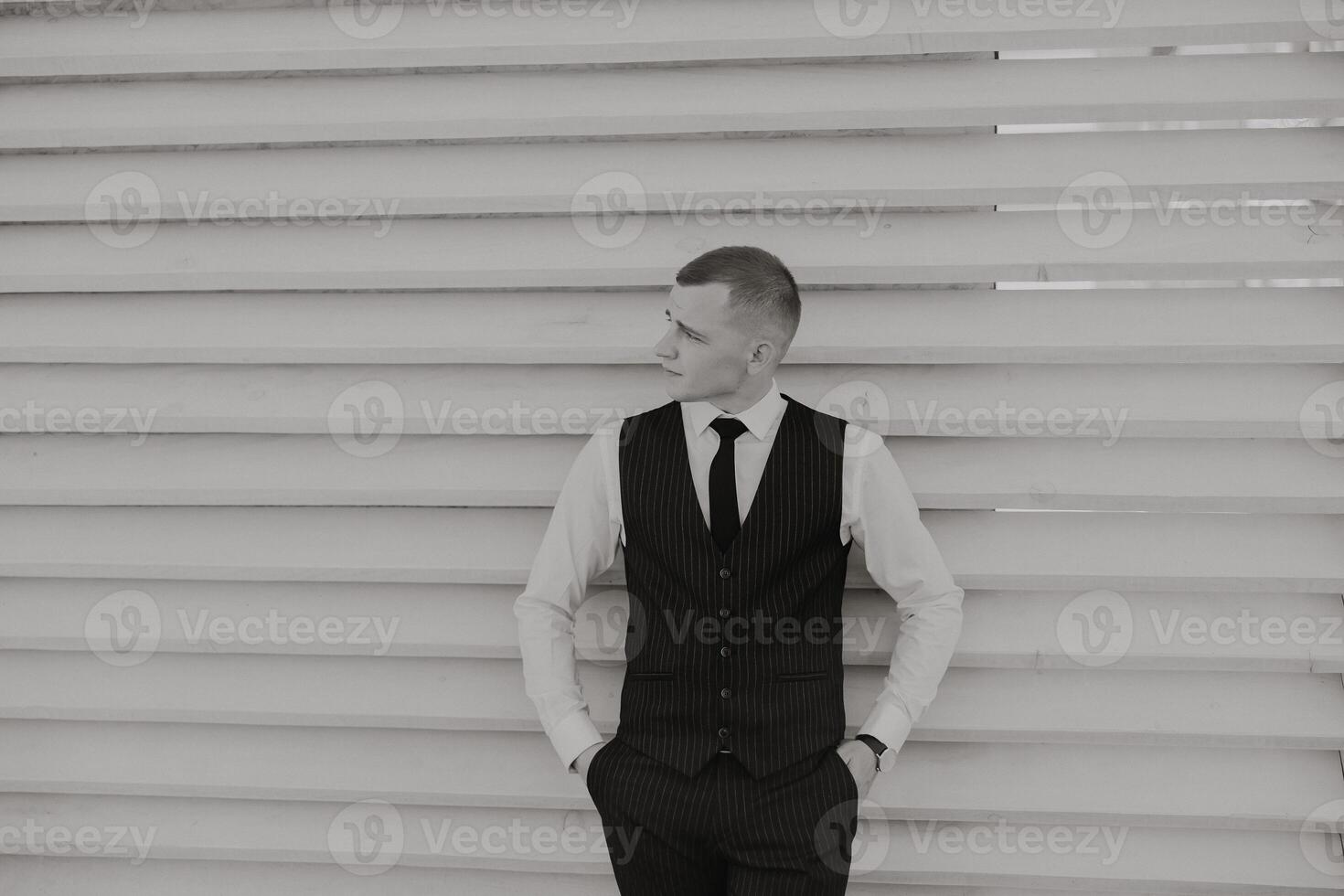 Portrait of a handsome young groom on an autumn day outdoors in an elegant suit. Outdoor photo. Handsome man in a business suit. photo