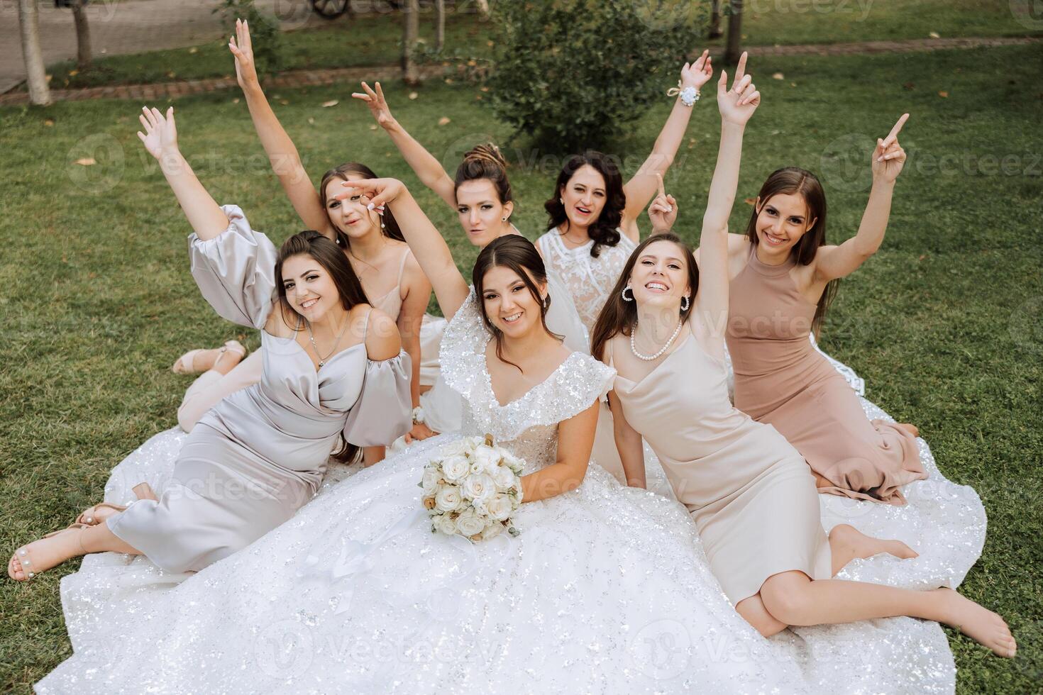 Wedding photography. A brunette bride in a white dress with a bouquet and her brunette girlfriends photo