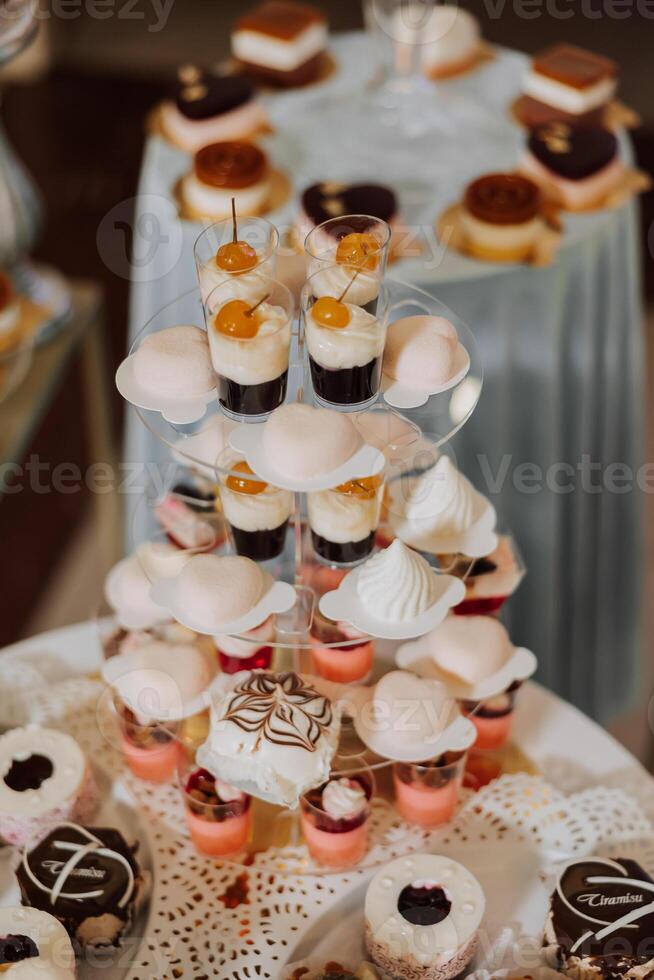 Almond cookies, sweet cakes for a wedding banquet. A delicious reception, a luxurious ceremony. Table with sweets and desserts. Delicious colorful French desserts on a plate or table. Candy bar. photo