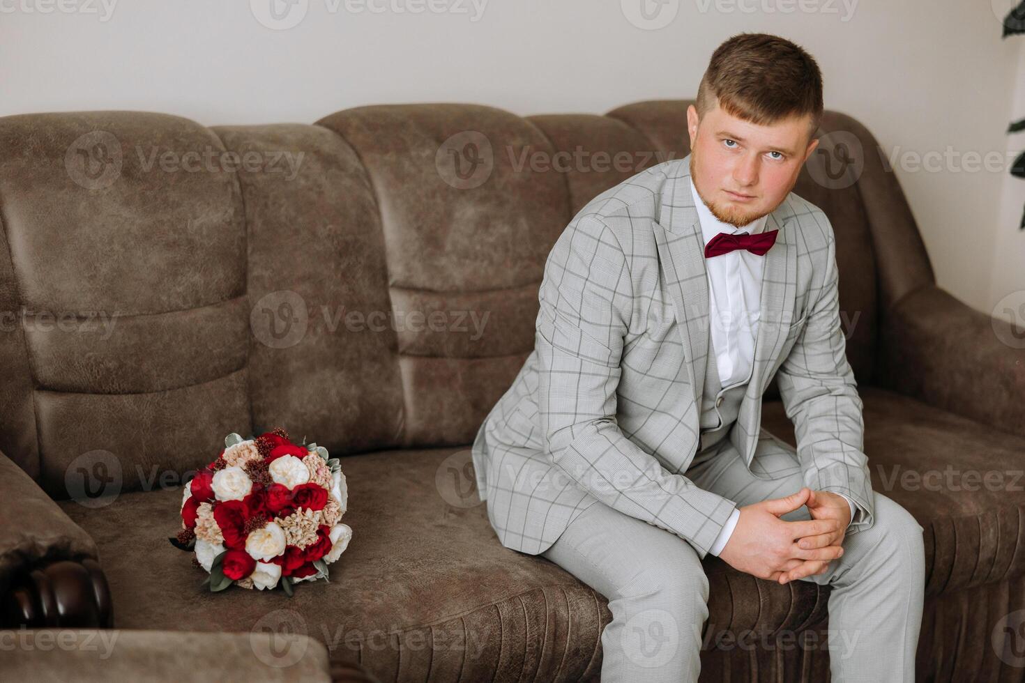 groom with a bouquet of roses, groom with bouquet, groom with a wedding bouquet, a young man with a wedding bouquet on his hand, well suited man photo