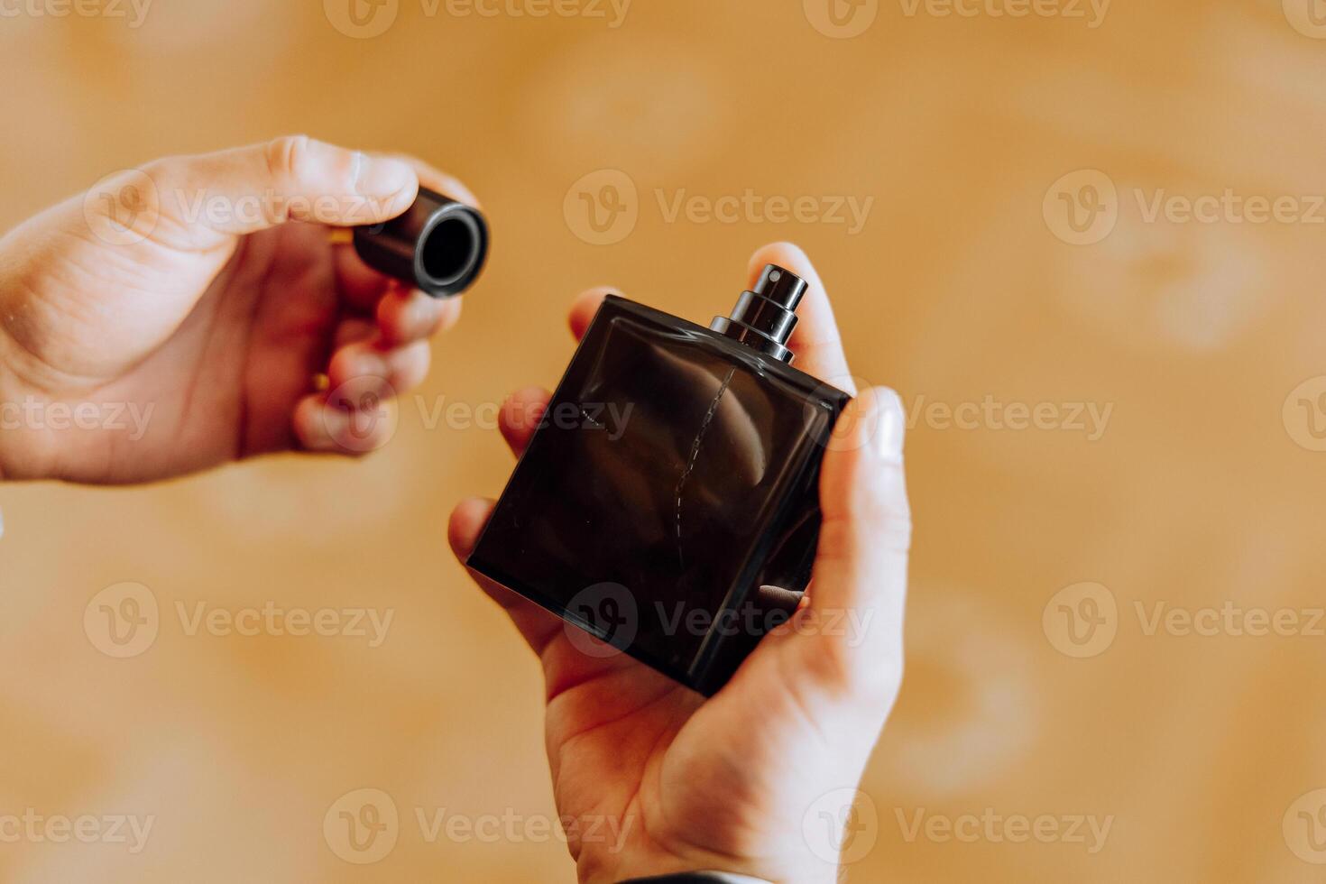 Masculine perfume. Man perfume, fragrance. Male fragrance and perfumery, cosmetics. Man holding up bottle of perfumery. Cologne bottle. photo