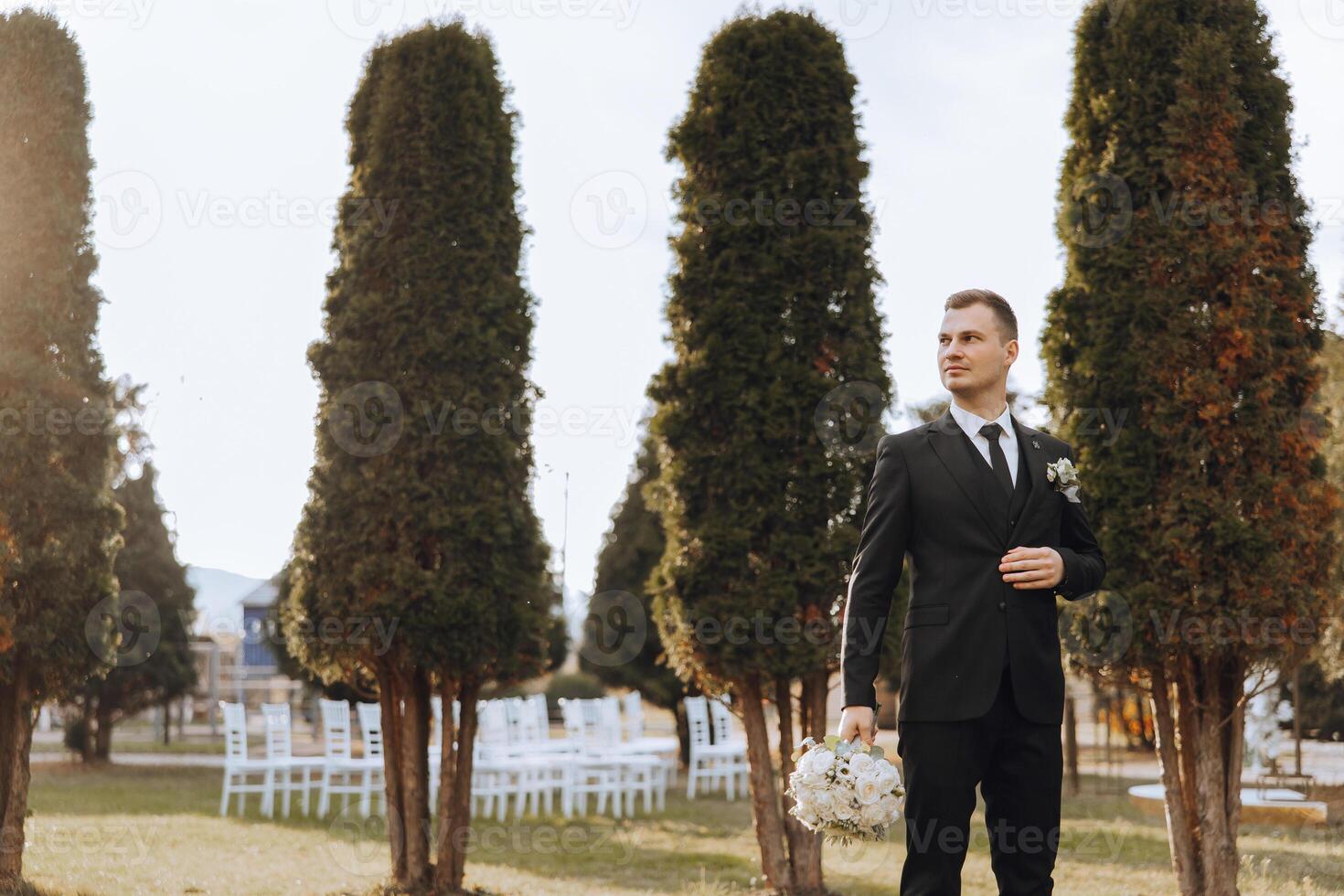 Portrait of a handsome young groom on an autumn day outdoors in an elegant suit. Outdoor photo. Handsome man in a business suit. photo