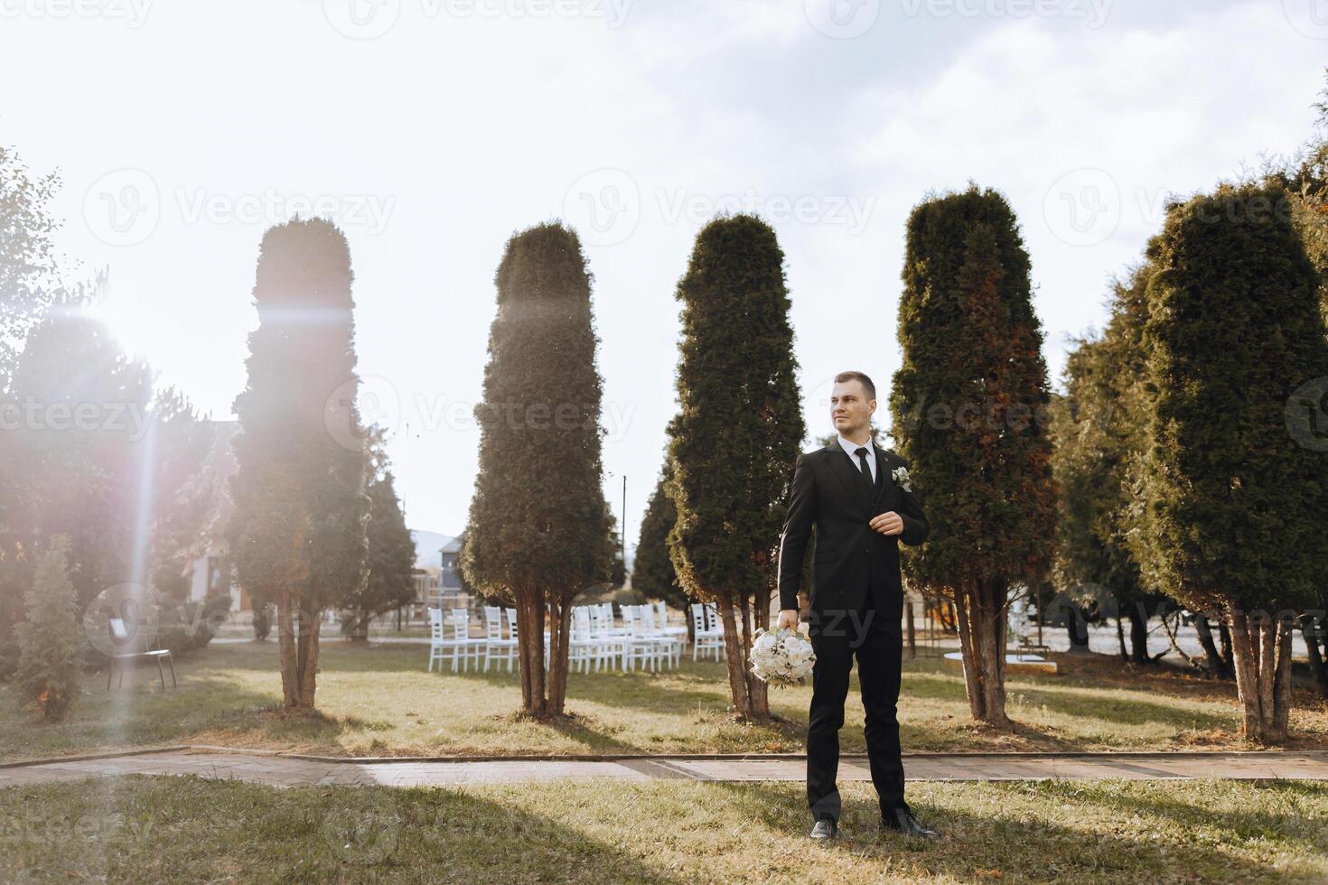 Portrait of a handsome young groom on an autumn day outdoors in an elegant suit. Outdoor photo. Handsome man in a business suit. photo