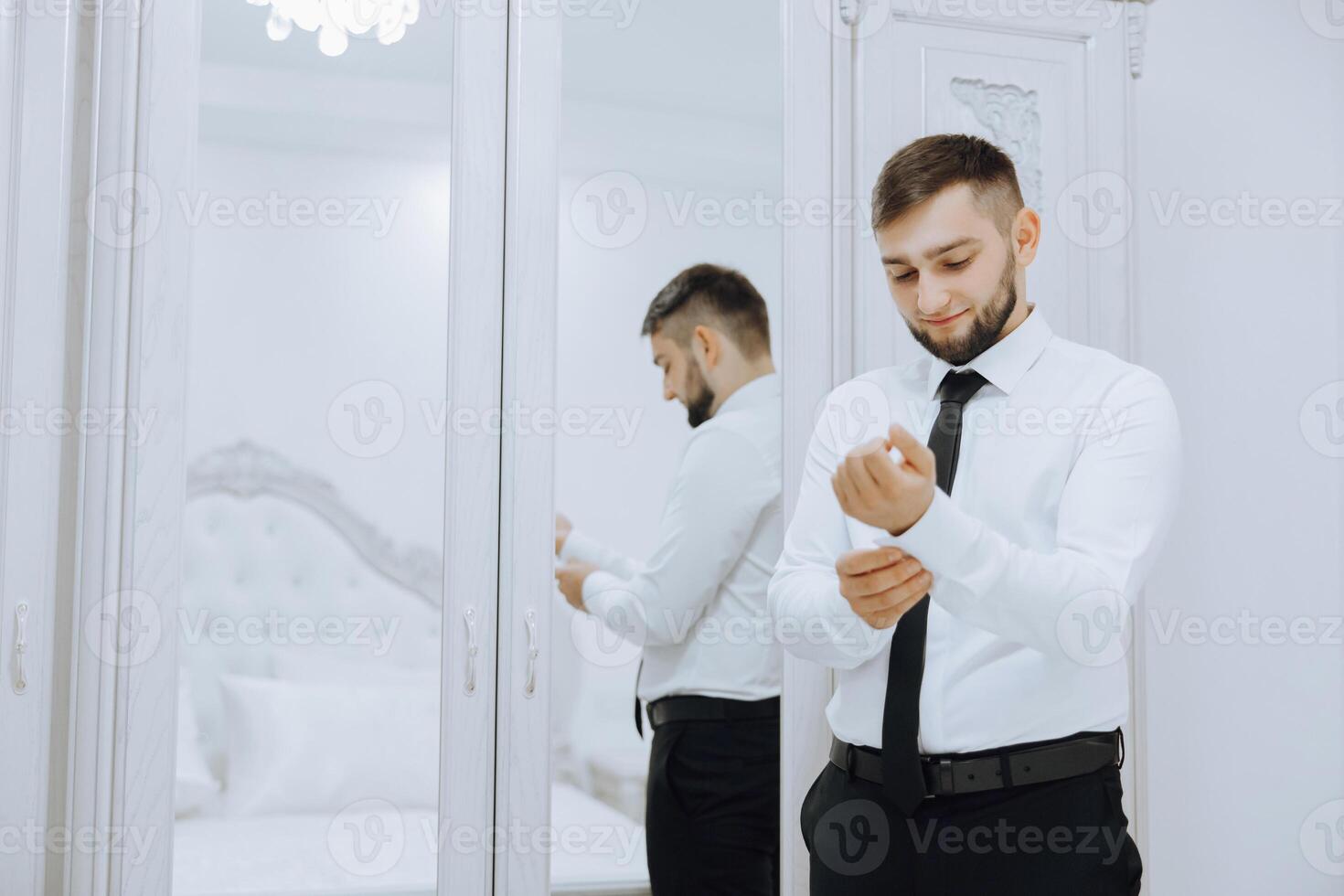 The man put on his shirt and straightens cufflinks. The groom fasten cufflinks on the cuffs of the shirt. The businessman fasten cufflinks on the cuffs of the shirt. Concept successful businessman. photo