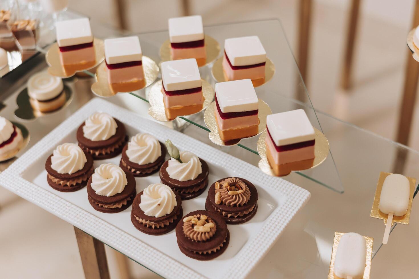 Almond cookies, sweet cakes for a wedding banquet. A delicious reception, a luxurious ceremony. Table with sweets and desserts. Delicious colorful French desserts on a plate or table. Candy bar. photo