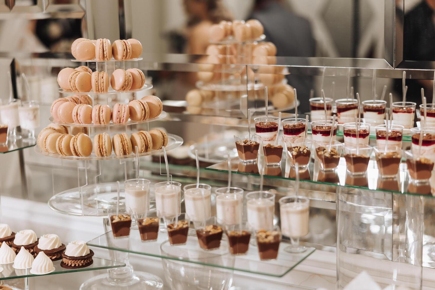 Almond cookies, sweet cakes for a wedding banquet. A delicious reception, a luxurious ceremony. Table with sweets and desserts. Delicious colorful French desserts on a plate or table. Candy bar. photo