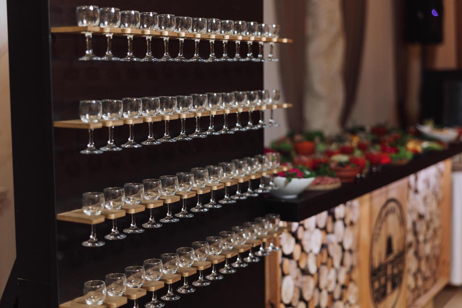 Champagne glass stand at a wedding party. Glasses for alcoholic drinks on a black wooden stand. Alcohol. Champagne. Celebration. photo