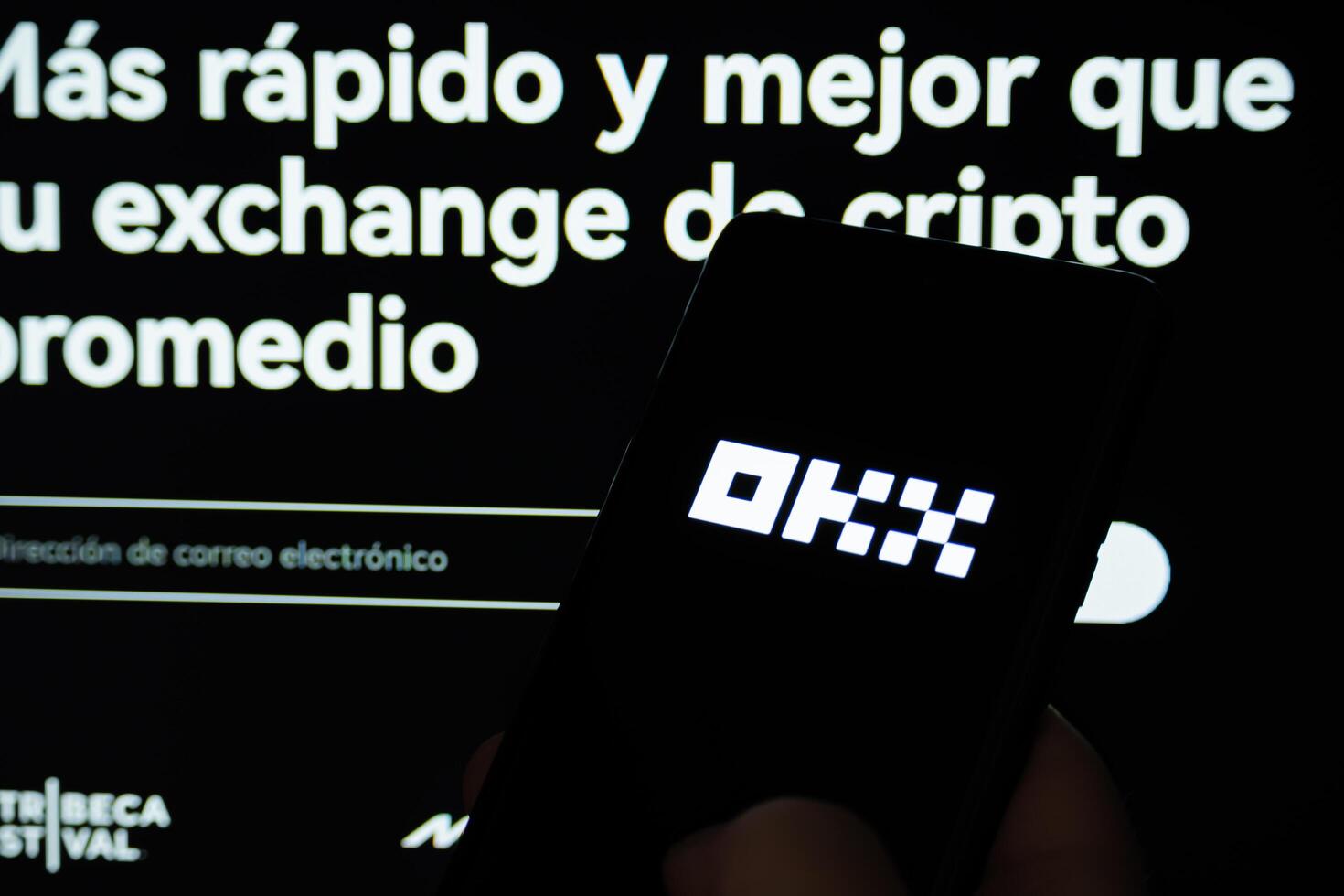 Cordoba Province, Argentina, March 11, 2024, OKX application opening on a cell phone. In the background you can see the official OKX page. photo