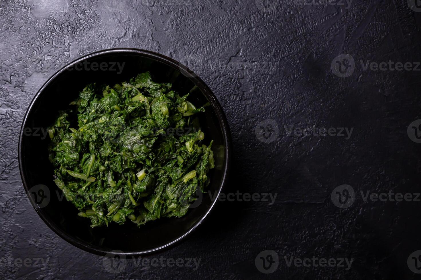 Boiled chard in a bowl on a dark background. photo