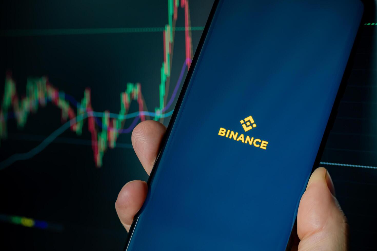 Cordoba Province, Argentina, March 11, 2024, Binance mobile app running at smartphone screen with a trading page at background. photo