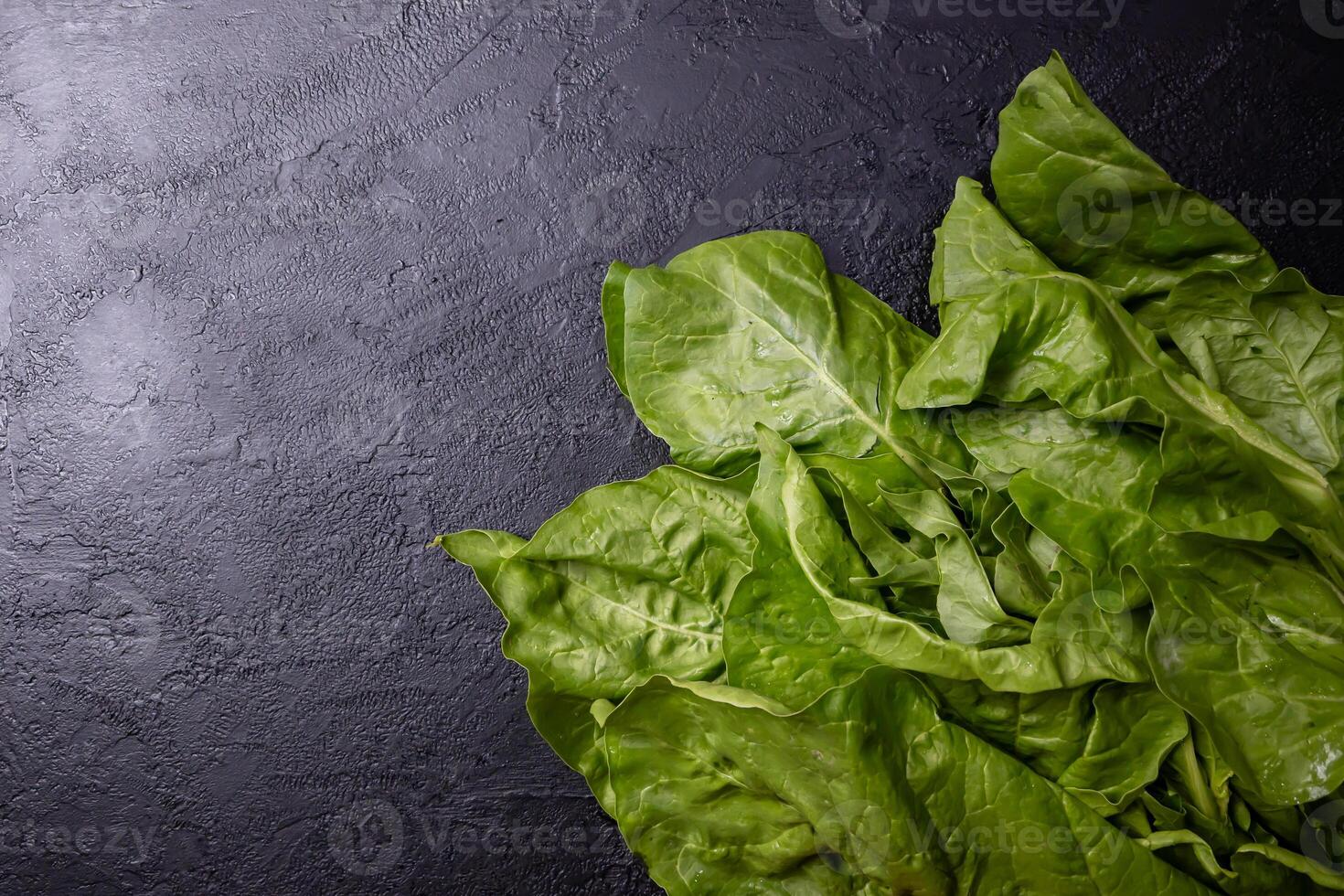 Chard leaves placed on a black table. photo