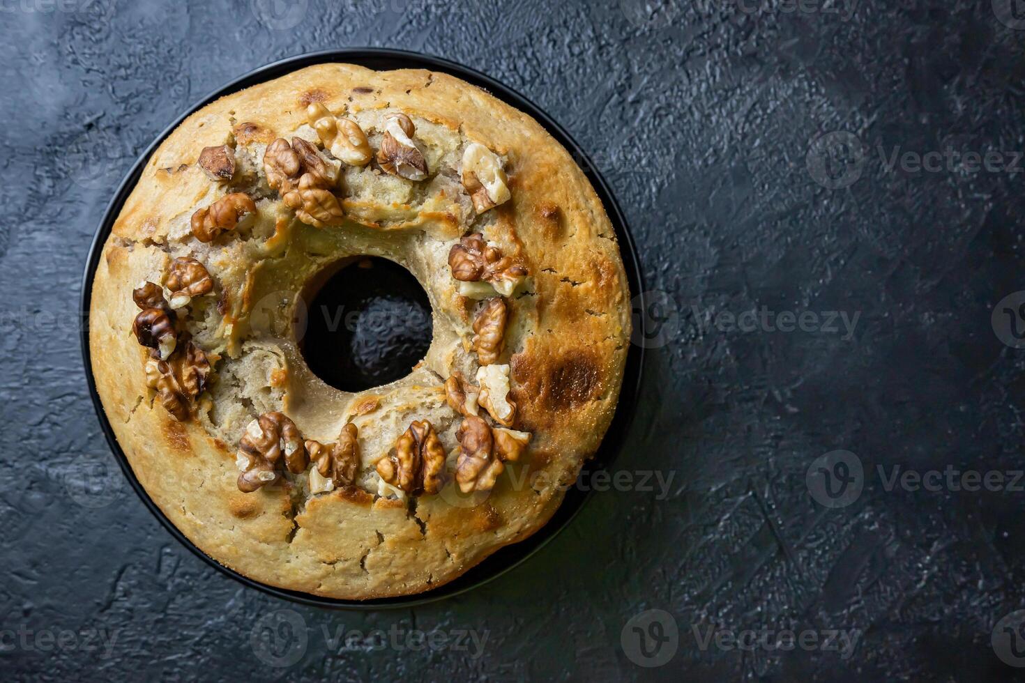 Walnut pudding on a plate on a dark table. photo