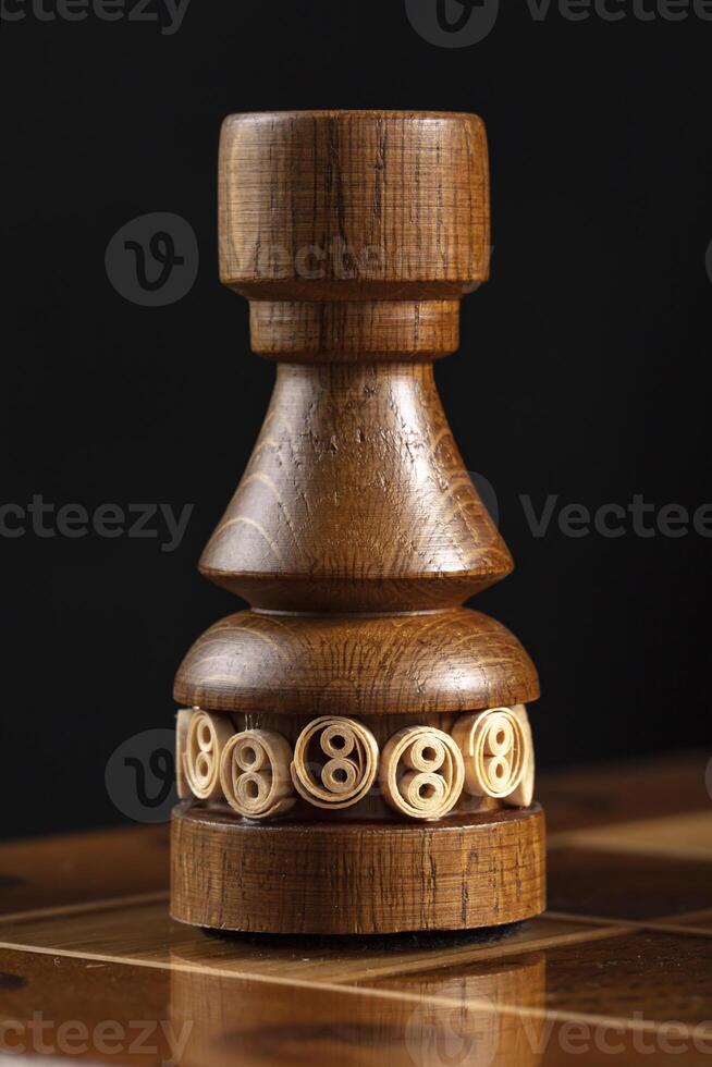 Chess piece of wood black rook. A puzzle game with tricky combinations that requires planning and thinking. photo