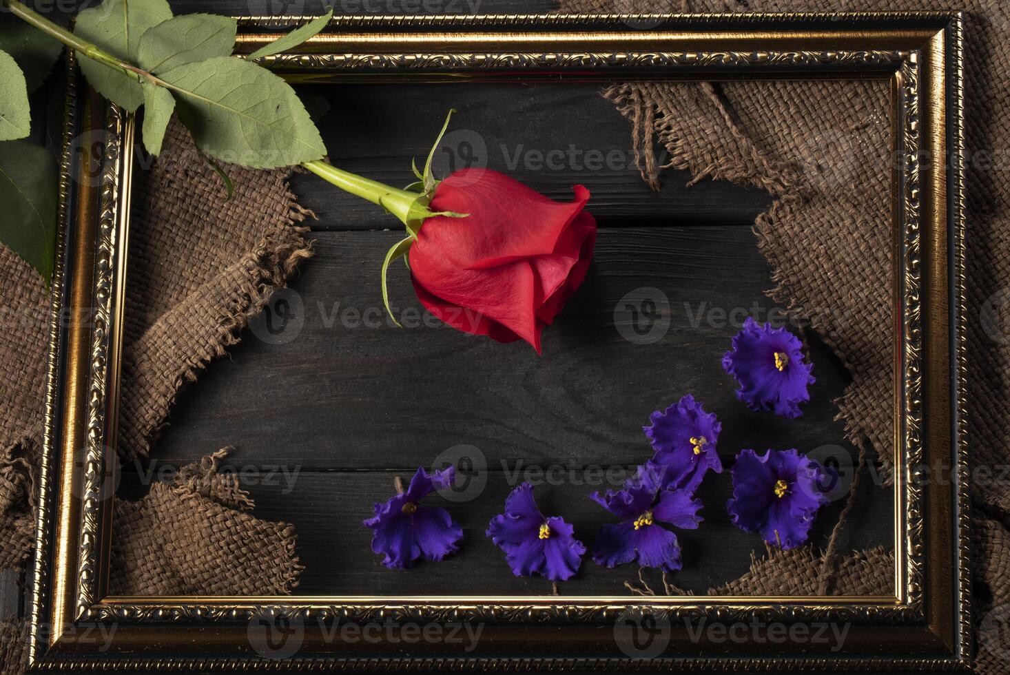 en un hermosa marco, piezas de lienzo, un rojo Rosa y violetas en un de madera antecedentes. decoración y decoración. foto