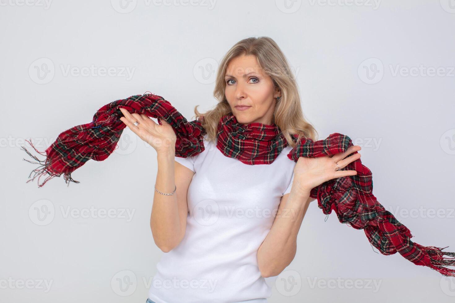 un hermosa adulto mujer olas un a cuadros calentar bufanda. foto